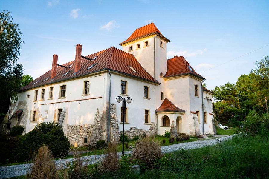 Piotrowice Nyskie Palace at golden hour, tower and red roofs in evening light